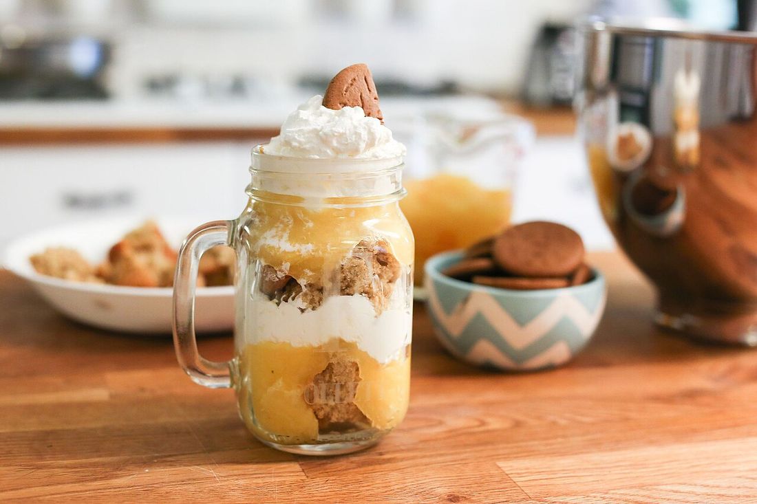 Doce em camadas num pote de vidro com alça, ao lado de biscoitos