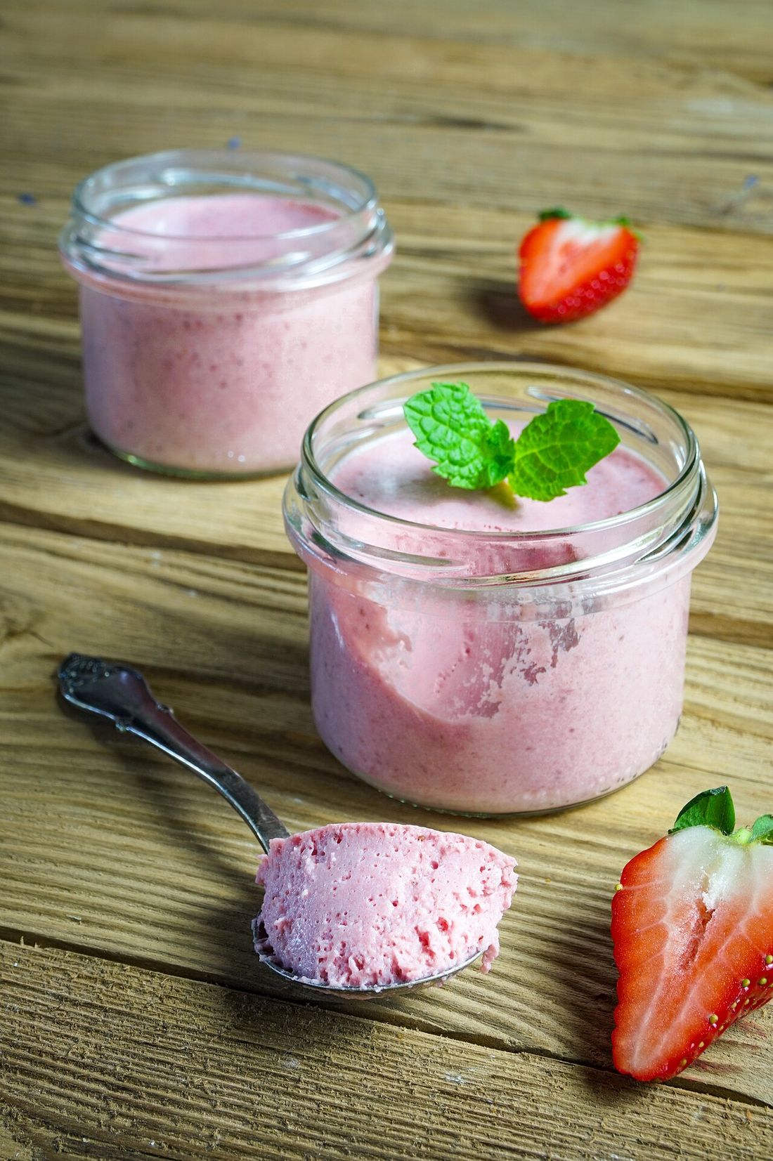 Potinhos de doce de morango com morangos frescos ao lado