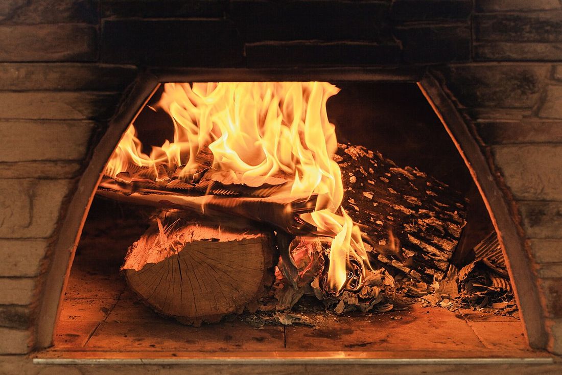 Fogo de lenha aceso dentro de um forno de pizza