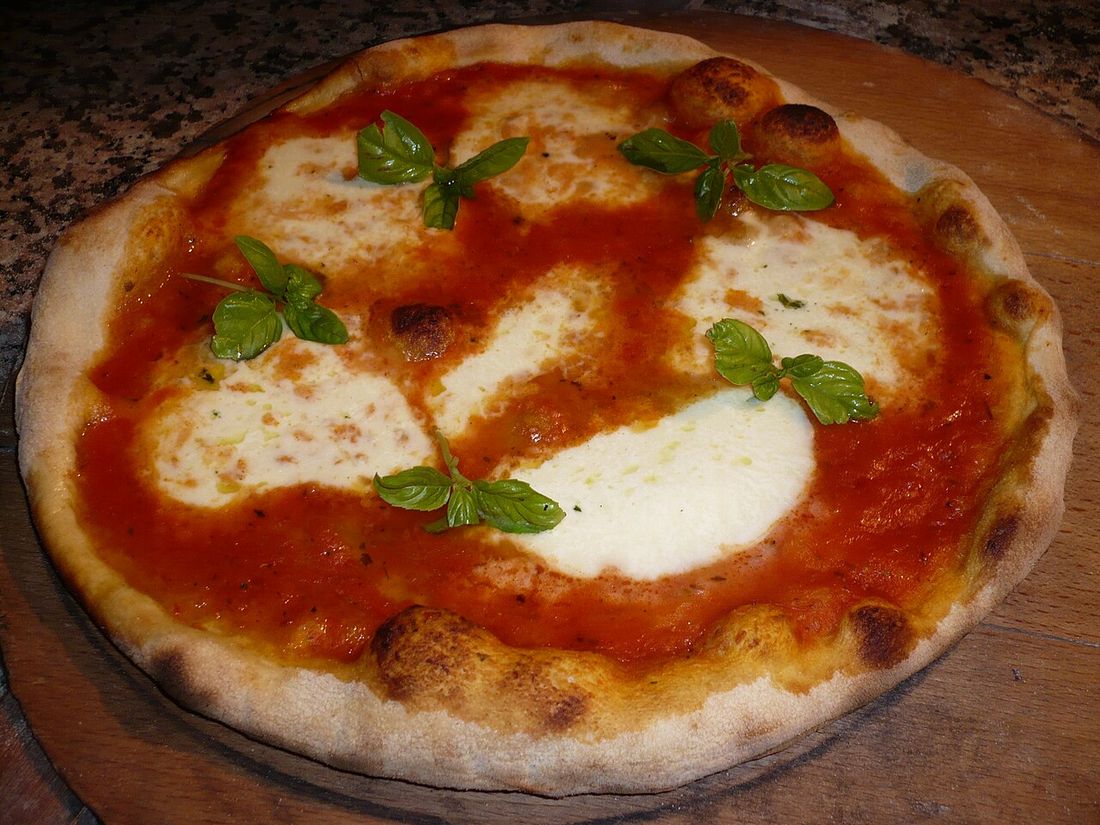Pizza margherita com manjericão sobre uma tábua