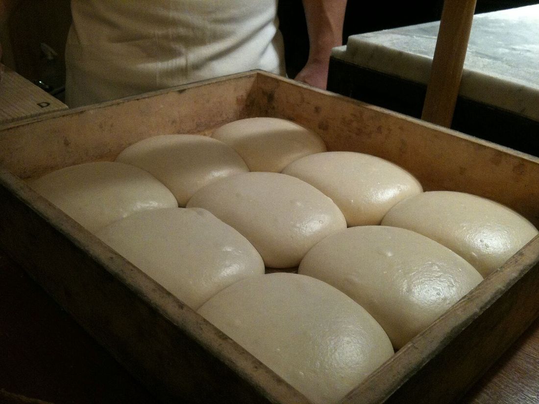 Bolas de massa de pizza fermentando numa caixa